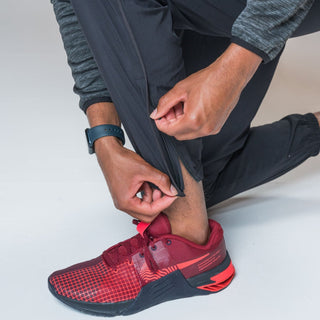 Close up view of our THETA core gym wear trackie ankle zip. These trackies are made for functional fitness and general gym wear use. Featuring the functionality of our ankle zips and paired with red nike metcon 8's.